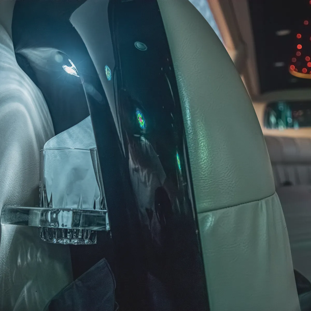 Kristallglas im Halter der Stretch Limo, dahinter der beleuchtete Sternenhimmel